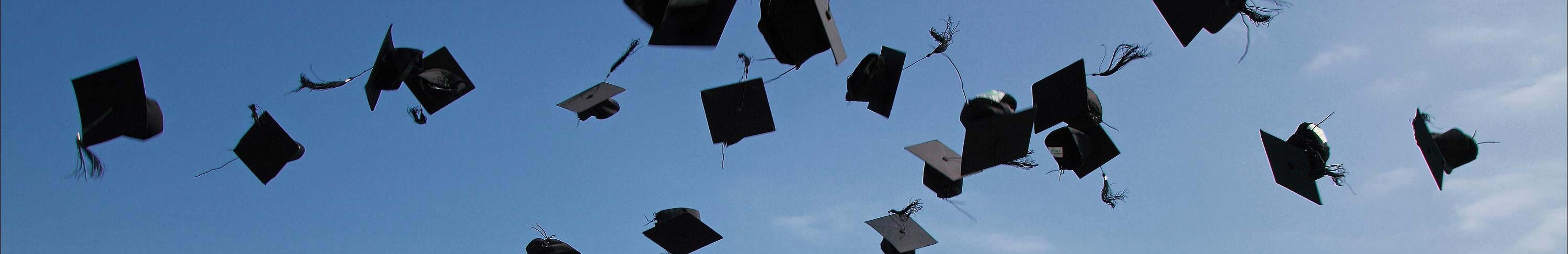 Student graduation hats in the air